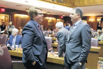  ?? DARRON CUMMINGS/AP ?? House Minority Leader Phil GiaQuinta, D-Fort Wayne, speaks with Rep. Todd Huston, R-Fishers, during the opening day of the session at the Statehouse on Jan. 6, 2020, in Indianapol­is.