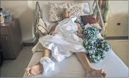  ??  ?? Maria Martinez Espada, 83, a patient who suffered a broken hip during Hurricane Maria, lies in a bed in Hospital El Maestro in San Juan, the capital. The hospital remained on emergency generator power, and surgeons could not operate on her because of a...