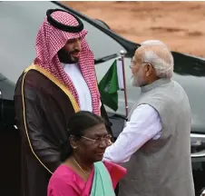  ?? — AFP photo ?? Indian President Droupadi Murmu (front) walks past Modi greeting his Saudi Arabian counterpar­t and Crown Prince Mohammed bin Salman as the latter arrives for a ceremonial reception at the President House a day after the G20 summit in New Delhi.