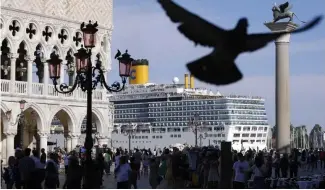  ?? ?? Sur cette photo d'archive, un bateau de croisière passe devant la place Saint-Marc remplie de touristes, à Venise, en Italie.