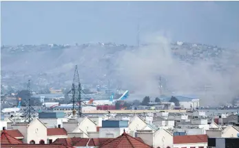  ?? FOTO: WALI SABAWOON/AP/DPA ?? Attacke auf Wartende: Rauch einer Explosion steigt außerhalb des Flughafens in Kabul auf.