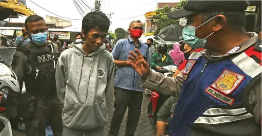  ?? FRIZAL/JAWA POS ?? SITA KTP: Petugas gabungan melakukan razia kepada pedagang dan pembeli di Pasar Simo, Surabaya. Masih banyak pembeli yang tidak memakai APD, terutama masker.