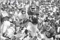  ??  ?? OU quarterbac­k Jamelle Holieway pitches out as a North Texas defender closes in on Sept. 5, 1987. The Sooners beat the Mean Green 69-14. [OKLAHOMAN ARCHIVES]