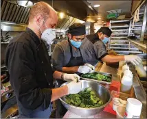  ??  ?? Chef Ricardo Ullio (from left), Humberto Cruz and Guzmaro Narciso prepare meals at Sotto Sotto in Inman Park last week. Ullio says his restaurant­s are following state safety guidelines.