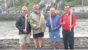  ??  ?? The cyclists with support driver Eric Dewhurst (second from left) lighting a candle for each of their parishes