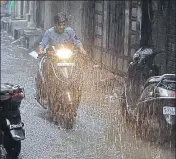  ?? SONU MEHTA/HT PHOTOS ?? A car (top) navigates a waterlogge­d street near ITO in central Delhi on Saturday morning. A man rides a scooter in Gandhi Nagar area in the downpour.