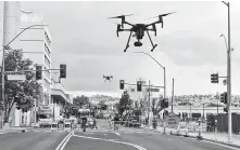  ?? Scott Sonner / Associated Press ?? Two drones fly above Reno, Nev., as part of a NASA simulation, the first time such tests have been conducted in an urban setting.