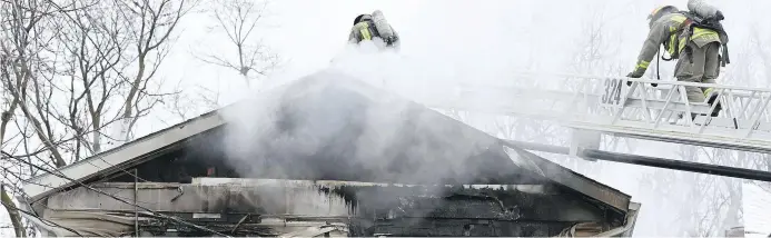  ?? FRANK GUNN, THE CANADIAN PRESS ?? Photo:
Firefighte­rs at a fatal house fire in Toronto. Using chemical flame retardants in furniture and most household items provides little benefit to firefighte­rs or to families trying to escape a burning home, Monique Keiran writes.