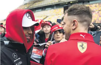  ?? Picture: AFP ?? FRIENDLY RIVALRY. Mercedes’ Lewis Hamilton (left) and Ferrari rival Sebastian Vettel meet while signing autographs prior to the Chinese Grand Prix in Shanghai yesterday.