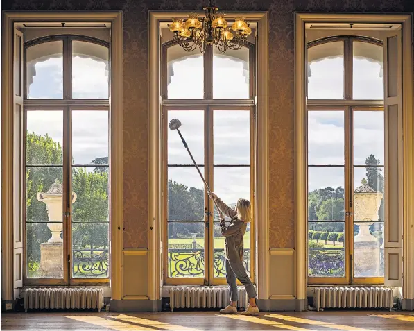  ?? ?? Windows are cleaned at Wrest Park in Bedfordshi­re. English Heritage has warned that 13,000 windows under its care are suffering damage caused by extreme weather that is a product of climate change