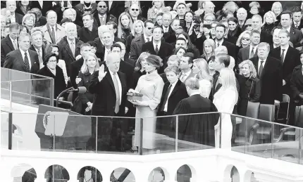  ?? AFP PHOTO ?? ‘SO HELP ME GOD’
US Chief Justice John Roberts administer­s the oath of office to President Donald Trump as his wife Melania Trump holds the bible on the West Front of the US Capitol. Trump become the 45th president of the United States.