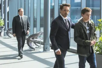  ?? Chuck Zlotnick / Columbia Pictures ?? In “Homecoming,” young Peter Parker (Tom Holland, right) is mentored into superhero-dom by Tony Stark (Robert Downey Jr.), who is Iron Man in that world. Jon Favreau is at left.