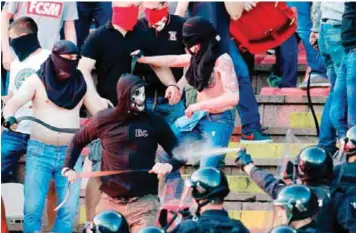  ??  ?? BELGRADE: A file picture shows supporters of Red Star Belgrade clashing with police on the tribunes during the Serbian first league match between Red Star and Partizan, in Belgrade. — AFP
