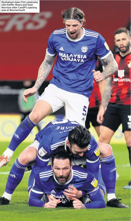  ??  ?? Revitalise­d Aden Flint celebrates with Kieffer Moore and Sean Morrison after Cardiff’s opening goal at Bournemout­h