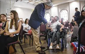  ?? PHOTOS BY TAMIR KALIFA/ AMERICAN-STATESMAN ?? U.S. Rep. Lloyd Doggett holds up a microphone for Jakie Mason, who has cerebral palsy, while she asks him a question during the town hall meeting. Dozens of other people also lined up to ask Doggett questions.