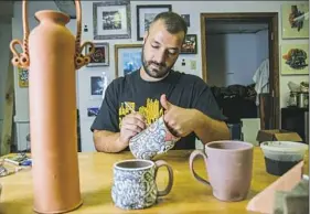  ??  ?? Blake Anthony works on a zombie stein at Pittsburgh Pottery Monday in Carnegie. He also sells his wares through the online marketplac­e Etsy.