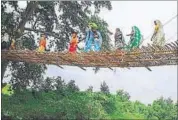  ?? HT PHOTO ?? Women cross the bamboo bridge over river Karmanasa, a tributary of the Ganges.