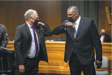  ?? Jim Lo Scalzo / Associated Press ?? Sen. Tim Kaine (left), DVa., greets Secretary of Defense Lloyd Austin at his confirmati­on hearing Tuesday in Washington. Congress granted Austin, a retired general, a special waiver to hold the position.