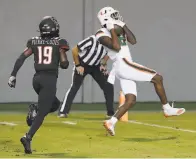  ?? Ethan Hyman / The News & Observer ?? Miami’s Dee Wiggins pulls in a 39yard touchdown reception ahead of N. C. State’s Joshua PierreLoui­s.