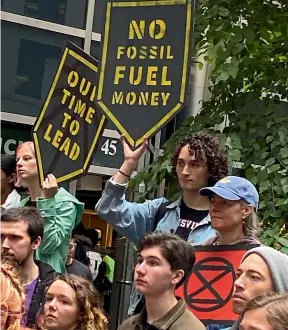  ?? AP (above), GETTY ?? Above: Climate activists in New York outside the offices of BlackRock, the world’s biggest asset manager. Left: Pollution blocks the sun in Bangkok.