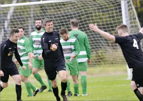  ??  ?? Carbury’s Steve Feeney celebrates scoring the winner against MCR with team-mates Gareth Kelly and Gerry Brennan. Pics: Carl Brennan.