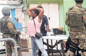  ??  ?? A woman positions herself for inspection at a military checkpoint in Mount Salem, St James, the first declared zone of special operations, recently.