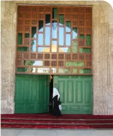  ?? (Leora Leeder) ?? THE DOME of the Rock is reflected in the windows as a woman enters one of the buildings on the Temple Mount.