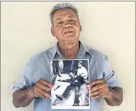  ??  ?? This photo provided by STORYCORPS shows Juan Romero holding a Los Angeles Times photograph that shows Romero with Sen. Robert F. Kennedy at the Ambassador hotel in Los Angeles moments after Kennedy was shot.