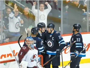  ?? CP PHOTO ?? From left, Kyle Connor, Patrik Laine, Blake Wheeler and Dustin Byfuglien celebrate Laine’s goal against Colorado Avalanche goaltender Semyon Varlamov during the third period of Friday’s game in Winnipeg.