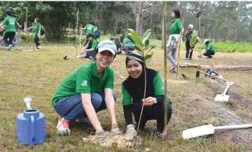  ??  ?? Naim staffers plant a tree during a forest conservati­on programme.