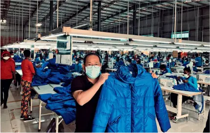  ?? (RWANDA DEVELOPMEN­T BOARD) ?? A Pink Mango C&D worker shows a jacket the factory makes on
June 9, 2020