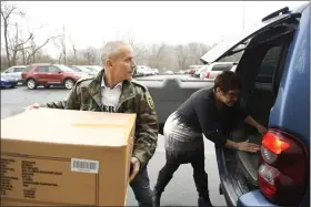  ??  ?? Doug and Liz Graybill of Veterans Making a Difference load a donation of Heat Holders socks from Boscov’s East into their car January 14