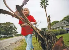  ?? ELIZABETH CONLEY/HOUSTON CHRONICLE VIA AP ?? Alfa Alamia cleans up her brother’s yard in Palacios, Texas following Hurricane Nicholas on Tuesday. Alamia has lived in Palacios since she was 12.