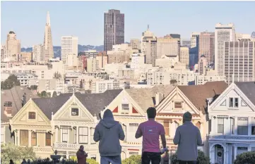  ??  ?? The silhouette­s of pedestrian­s stand in front of Victorian homes and the downtown skyline in San Francisco, California. — WP-Bloomberg photo