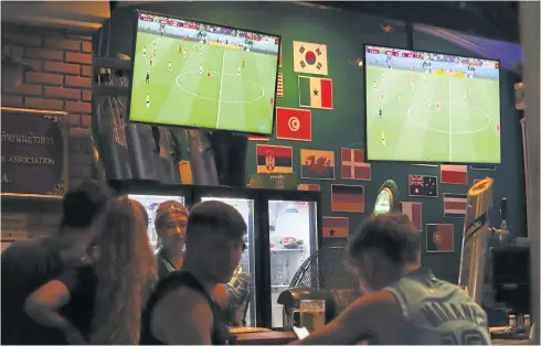  ?? ?? A 2022 World Cup match is broadcast at a Bangkok bar for patrons. The regulator unanimousl­y approved a draft cancelling the must have rule.