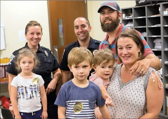  ?? Charlotte Observer/TNS/ALEX KORMANN ?? Charlotte (N.C.) Mecklenbur­g Police Department Officers Nikolina Bajic (left rear) and Lawrence Guiler stand with John and Sarabeth Ogburn and their children (from left), Birdie, 4; Huck, 5; and Revel, 2. Guiler and Bajic saved John Ogburn’s life a few...