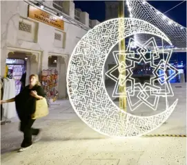  ?? GIUSEPPE CACACE/AGENCE FRANCE-PRESSE ?? WOMAN walks past decoration­s during the Muslim holy fasting month of Ramadan, at Al-Seef in Dubai, United Arab Emirates.