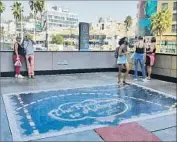  ?? Christophe­r Knight Los Angeles Times ?? VISITORS pause on “The Road to Hollywood” terrace at the Hollywood & Highland shopping center after the removal of the fiberglass daybed sculpture.