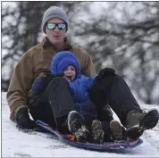  ?? MATT HAMILTON — CHATTANOOG­A TIMES FREE PRESS VIA AP ?? Ben Roth sleds down a hill along the banks of the Tennessee River with his son Avery, 4, on Saturday in Chattanoog­a, Tenn.