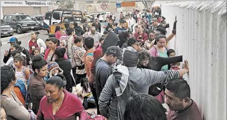  ?? ELLIOT SPAGAT/AP ?? People seeking political asylum in the United States line up to be interviewe­d in Tijuana, Mexico, just across the U.S. border south of San Diego.