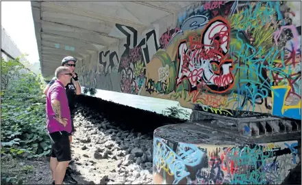  ?? KARENA WALTER/ STANDARD STAFF ?? Niagara Regional Police Constables Dennis Andree and Chad Davidson check out graffiti under Hwy. 406 near Fourth Ave. on Friday in St. Catharines.