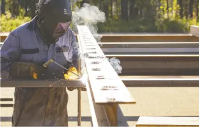  ?? RANDY VANDERVEEN / POSTMEDIA NEWS FILES ?? Smoke rises around a welder as he fits together the metal making up the skeleton of a new drive-in theatre screen built this summer in Evergreen Park. The Investment and Growth Strategy is aimed at diversifyi­ng Alberta's economy.