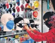  ??  ?? A shopkeeper arranges face masks at his shop in Jabalpur.
PTI