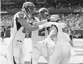  ?? DAVID BANKS/GETTY IMAGES ?? Falcons QB Matt Ryan (2) celebrates with Austin Hooper, right, after their 88-yard TD pass in the 4th quarter.