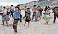  ?? RICK STEVES/RICK STEVES’ EUROPE ?? Jovial folk music groups in festive costumes bring life to the beaches of Nazare, a tradition since 1934.