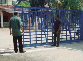  ?? PIC BY MOHD HELMI IRWADI ?? A security guard explaining the incident to a police officer at the Customs Department’s Narcotics Unit in Kampung Jijan in Seremban yesterday.