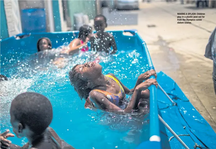  ??  ?? MAKING A SPLASH: Children play in a plastic pool not far from the Olympics canoe slalom course.