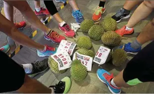  ??  ?? This one’s mine! Participan­ts taking photos of their durians before the run.