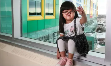  ?? CHRISTINA RYAN, POSTMEDIA CONTENT WORKS ?? Everly Tram, who has a rare genetic disorder called Apert Syndrome, holds up four fingers to show her age.