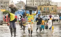  ?? DENIS ONYODI/INTERNATIO­NAL RED CROSS VIA AP ?? People carry their personal effects after Tropical Cyclone Idai in Beira, Mozambique. The small African country’s President Filipe Nyusi fears more than 1,000 may have by killed by the storm and in the aftermath.